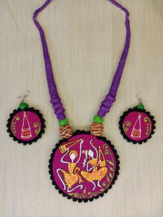 a necklace and earring set with an image of a woman on the front in purple