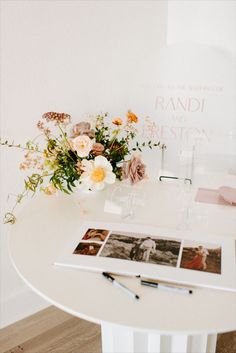 a white table with flowers and photos on it