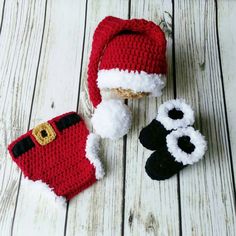 crocheted santa hat and mittens on white wood