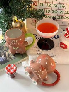 two ceramic elephants sitting on top of a table next to a cup and saucer