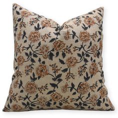 an orange and black floral pillow on a white background