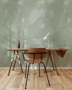 a wooden table sitting on top of a hard wood floor next to a chair and lamp