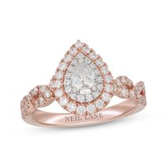 a rose gold ring with a pear shaped diamond in the center and two rows of diamonds on