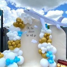 an airplane is flying over a sign with balloons