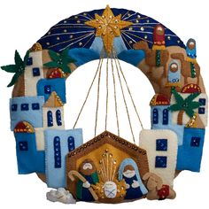 a blue and white christmas ornament hanging from a string with an image of a nativity scene on it