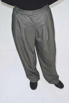 Mijeong Park pleat front wide leg trousers in charcoal grey. Relaxed fit, mid-rise, partially elasticated waistband, side seam pockets. Belt loops with hook and eye closure, zip fly, and unlined. 68% polyester, 22% rayon, 8% wool, 2% spandex. Mid weight suit fabric. Dry clean. Made in China. Fabric made in South Korea. Model wears size small. Model is 5’ 8”. Fits true to size. Measurements in inches: - XS: waist (Partially elasticated waistband) 25.5, hip 40, length 40.5 - S: waist (Partially el Mijeong Park, Classic Trousers, Suit Fabric, Fashion Pieces, Charcoal Color, Wide Leg Trousers, Individual Style, Online Clothing, Charcoal Grey