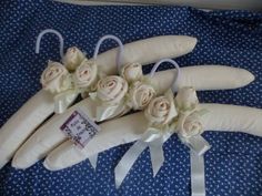 wedding bouquets made out of cloth and flowers on a blue bed sheet with white ribbons