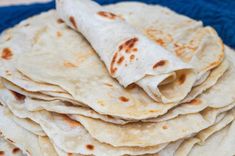 a stack of tortillas sitting on top of a blue towel