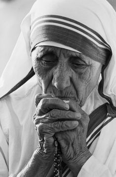 an old woman is holding her hands to her face while wearing a headdress