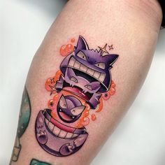 a tattoo on the leg of a person with an evil looking cat in it's mouth