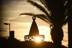 the sun is setting behind a decorative lantern