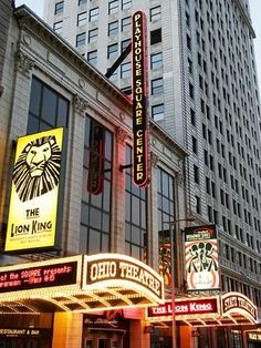 the lion king theatre in new york city is lit up with neon signs and advertisements