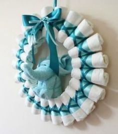 a blue and white wreath hanging on the wall with an elephant stuffed animal in it