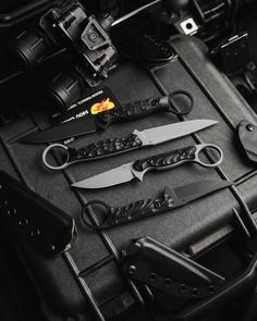 several different types of knifes and knives in a black case with other items on it