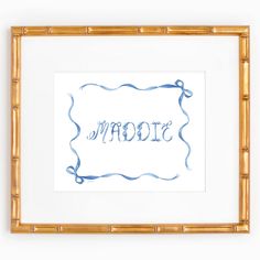 a frame with the word mom written in blue watercolor on white paper next to a bamboo mat