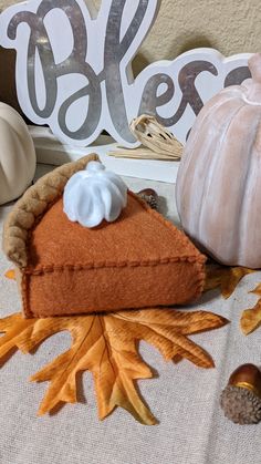 a piece of pie sitting on top of a table next to a pumpkin and acorn