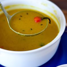 a spoon full of soup on top of a blue plate