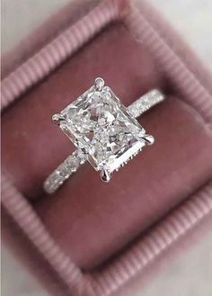 a princess cut diamond ring in a pink velvet box