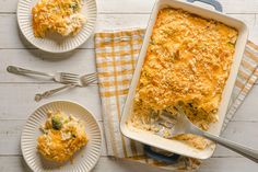 a casserole dish with broccoli and cheese on it next to two plates