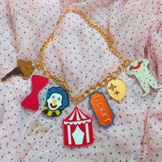 "*This colorful and unique Circus Themed necklace is super cool! It includes 7 lucky charms and a gold tone chain + 3\" extender. *The charms range from 1-2 inches tall.  *They were laser cut with a mix of mirror orange, mirror red, mirror silver, red, white, glittery blue, among even more acrylic colors!  *The pendants were designed digitally by BC, then laser cut from 1/8th of an inch thick acrylic. *They were secured together, and the back of design has a thin layer of black acrylic as a back Ouija Board Planchette, Clown Clothes, Dope Jewelry Accessories, Alt Clothing, Laser Cut Jewelry, Mirror Silver, Circus Theme, Dope Jewelry, Gold Charm Necklace