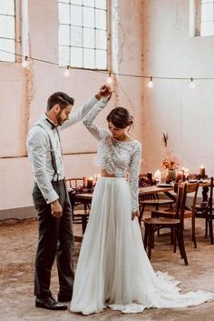 a man and woman standing next to each other in front of a table with candles