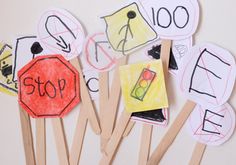 children's handmade paper cut out stop signs on wooden sticks with colored crayons