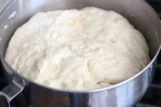 a metal pot filled with dough on top of a stove