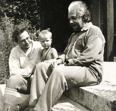 two men and a child sitting on a bench