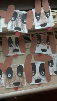 several pieces of paper cut out to look like dogs with their mouths open and eyes closed