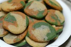 a white plate topped with green and yellow cookies