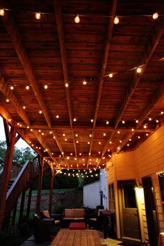 an outdoor covered patio with lights on the ceiling