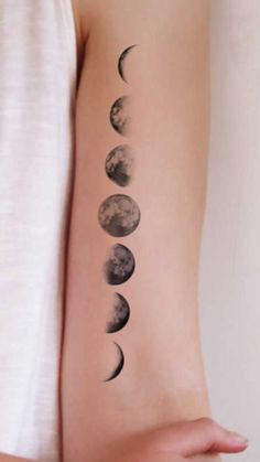 a woman's arm with phases of the moon on it