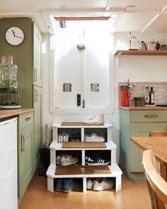 a kitchen filled with lots of counter top space and wooden shelves next to a window