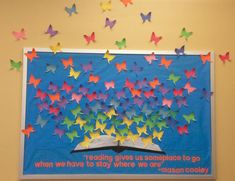 a bulletin board with colorful butterflies on it and a book in the middle that says reading gives us someplace to go