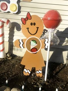 a paper cutout of a ginger holding a candy cane in front of a house