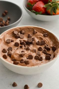 two bowls filled with chocolate pudding and strawberries on the table next to each other