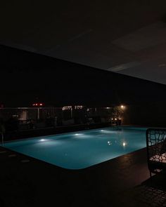 an empty swimming pool at night with the lights on