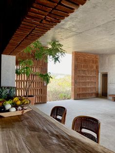 a wooden table topped with lots of fruit on top of a hard wood floored room