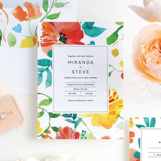 the wedding stationery is laid out on top of each other, including an orange flower