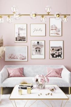 a living room with pink walls and pictures on the wall above the couch, coffee table