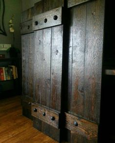 two wooden doors are open on the floor in front of a bookshelf and bookcase