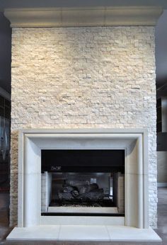 a fire place in the middle of a room with white bricks on the wall and floor