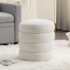 a pile of white towels sitting on top of a rug next to a gray chair