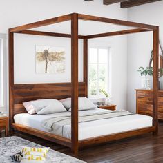 a bedroom with white walls and wood furniture, including a four poster bed frame in the middle