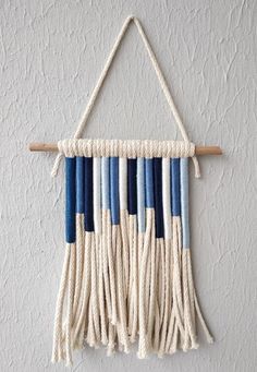 a wall hanging made out of rope with blue and white stripes on it's sides