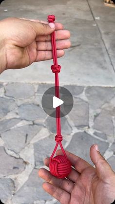 someone is holding a red rope in their hand