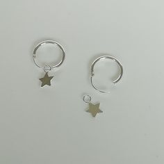 ▪︎ Sterling silver ear hoops with a tiny star charm. ▪︎ Dimensions-- Hoops: 12 x 1 mm Star: 5 mm. ▪︎ These hoops are handmade with hypoallergenic 925 sterling silver ▪︎ Please note: You can wear these hoops with or without the charm. ▪︎ Delicate star charm made with sterling silver. Perfect as a charm for necklaces, earrings or bracelets. ▪︎ All jewelry arrives in a gift box. We can include a gift message from you if required. ▪︎▪︎ Please read my shipping policies for shipping durations. ▪︎▪︎ Do Hypoallergenic Star Hoop Earrings For Everyday, Everyday Hypoallergenic Star Hoop Earrings, Sterling Silver Star Hoop Earrings With Ear Wire, Sterling Silver Star Huggie Earrings Minimalist Style, Everyday Silver Hoop Earrings With Star Charm, Minimalist Star Shaped Hoop Earrings, Sterling Silver Star Shaped Minimalist Huggie Earrings, Silver Small Hoop Jewelry With Star Charm, Hypoallergenic Star-shaped Hoop Earrings For Everyday