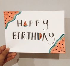 someone holding up a card with the words happy birthday written in watermelon slices