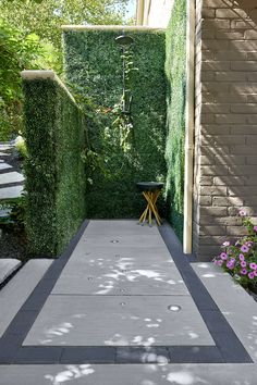 the walkway is lined with green hedges and flowers