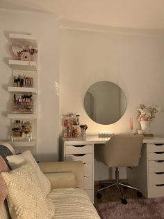 a living room with a couch, desk and mirror